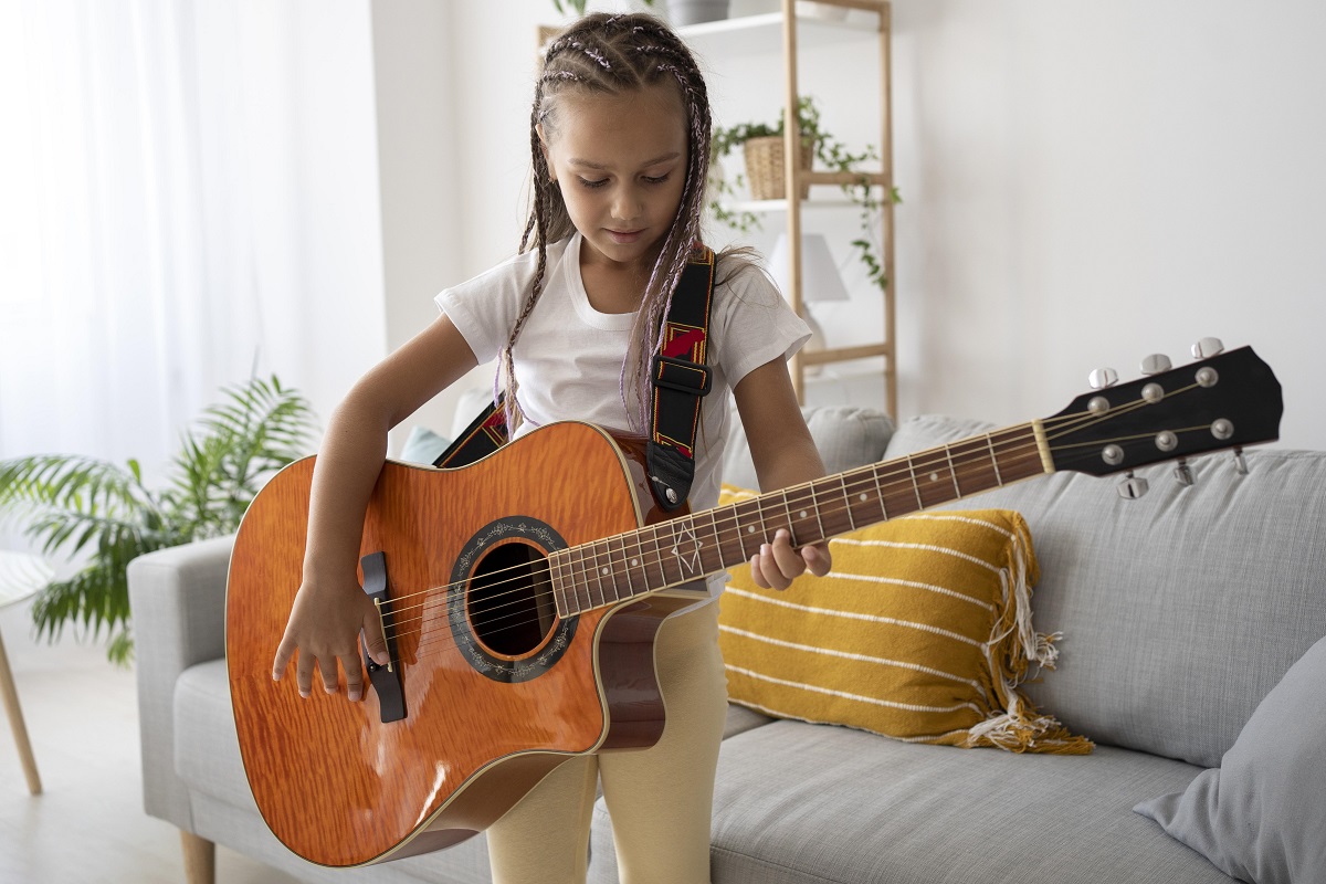 Garota adorável tocando violão em casa Garota adorável tocando violão em casa